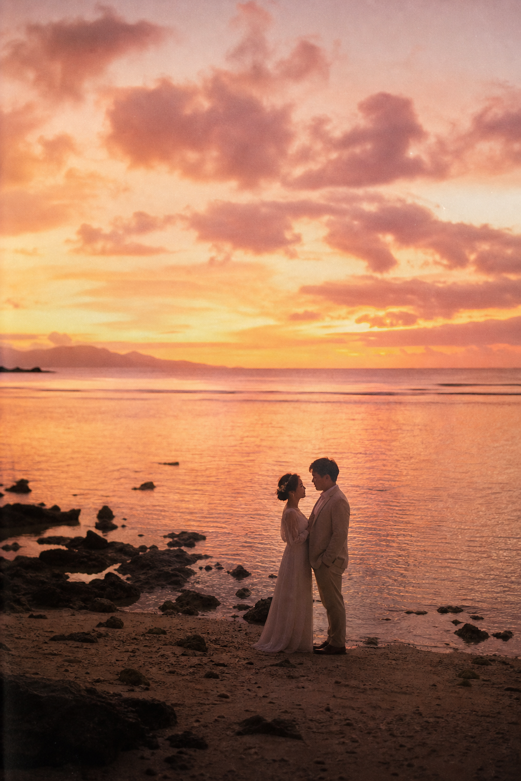 夕暮れの海辺で向かい合うカップルフォト